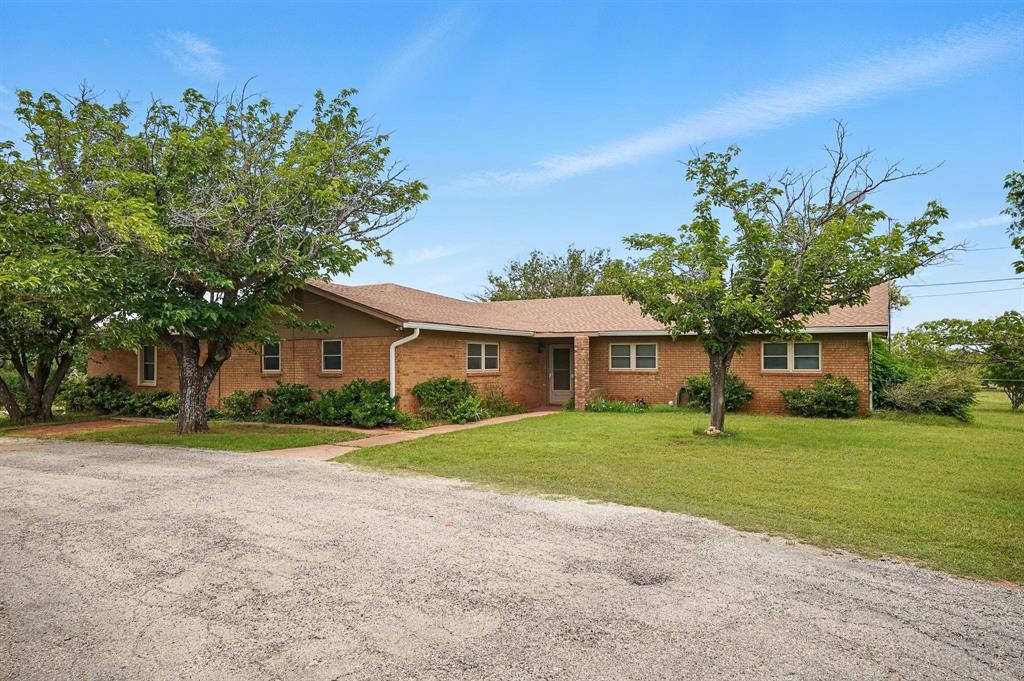 a front view of a house with a yard and trees