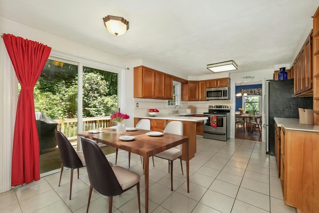 1 Kevin Circle Framingham, MA 01701 - Photo 12 of 25 a open dining room with stainless steel appliances a kitchen island a stove a table and chairs