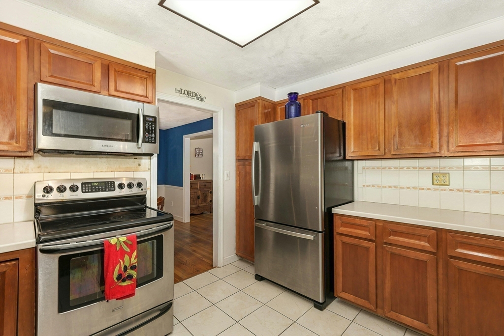 1 Kevin Circle Framingham, MA 01701 - Photo 14 of 25 a kitchen with stainless steel appliances granite countertop a refrigerator stove and microwave