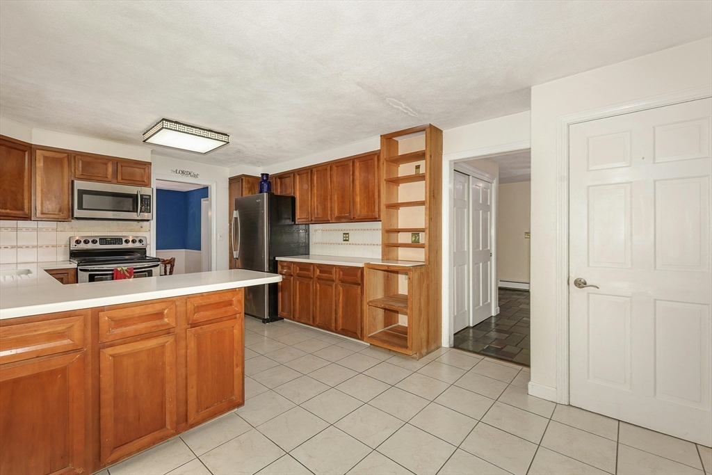 1 Kevin Circle Framingham, MA 01701 - Photo 15 of 25 a kitchen with stainless steel appliances a refrigerator and a stove top oven