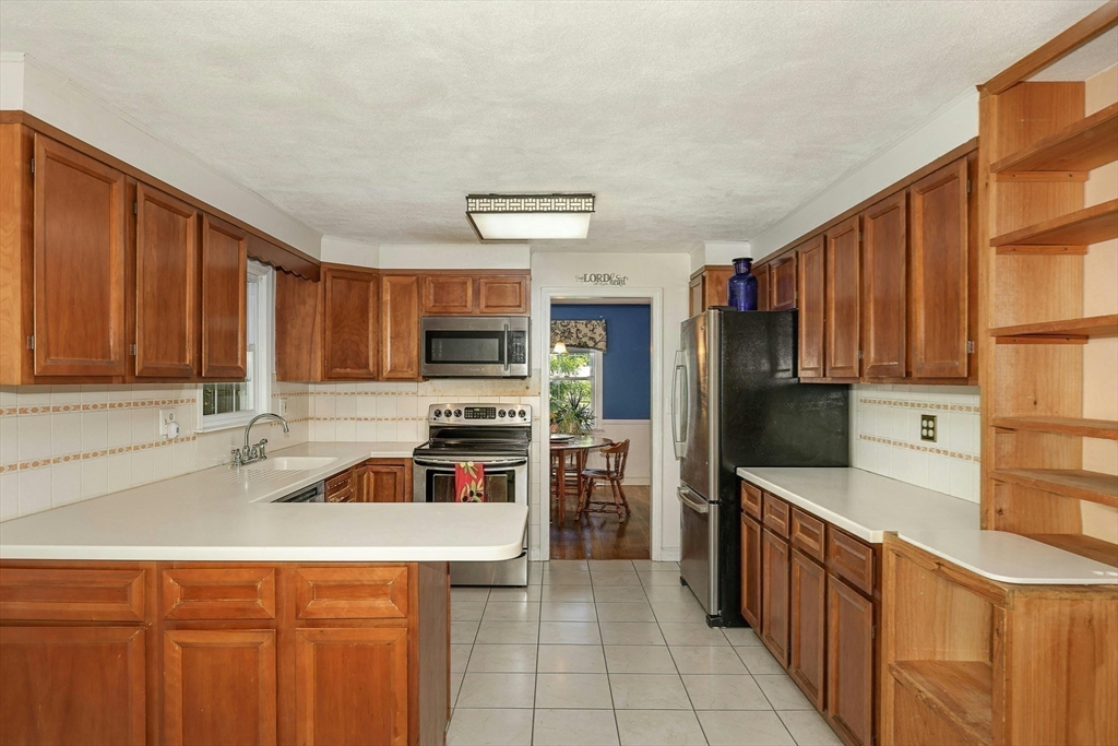 1 Kevin Circle Framingham, MA 01701 - Photo 16 of 25 a kitchen with stainless steel appliances a stove sink refrigerator and cabinets