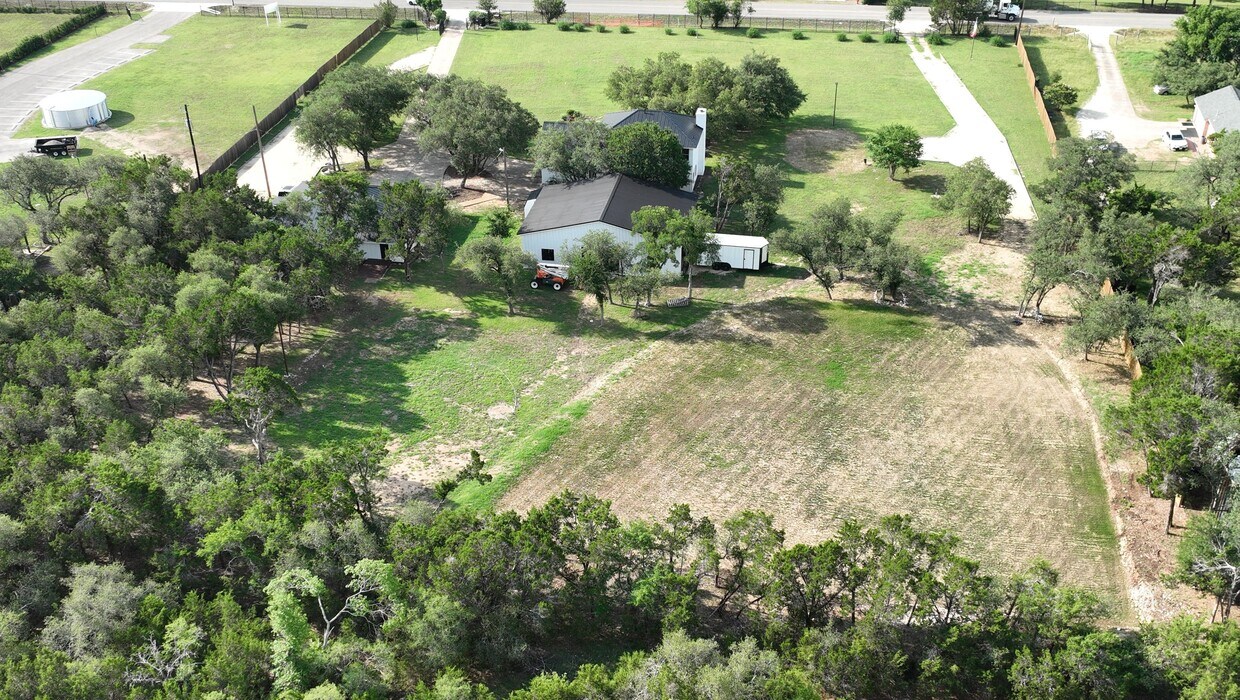 102 County Road 180 Leander, TX 78641 - Photo 7 of 25 An aerial perspective reveals a secluded estate nestled among verdant trees and sprawling grounds.
