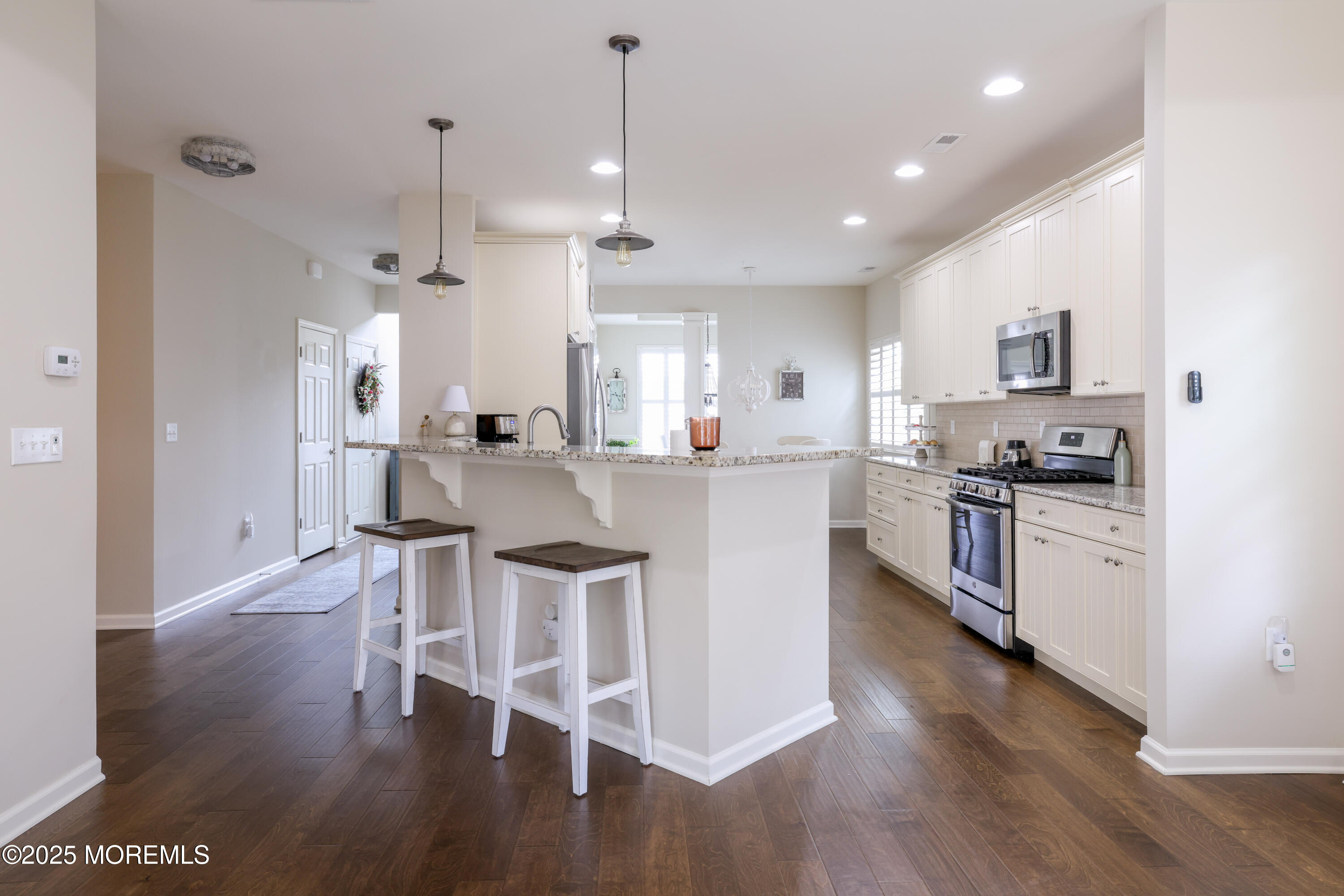 31 Garden Path Barnegat, NJ 08005 - Photo 15 of 43 a kitchen with stainless steel appliances kitchen island granite countertop a stove a sink a refrigerator and a dining table with wooden floor