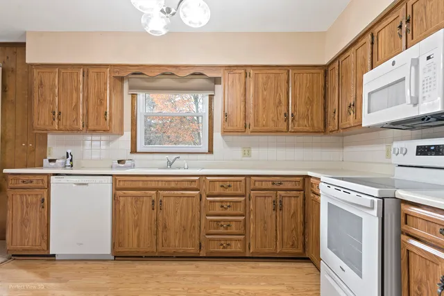 a kitchen with stainless steel appliances granite countertop a sink and cabinets with wooden floor
