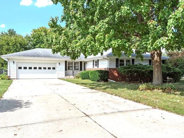 a view of a house with a yard and potted plants