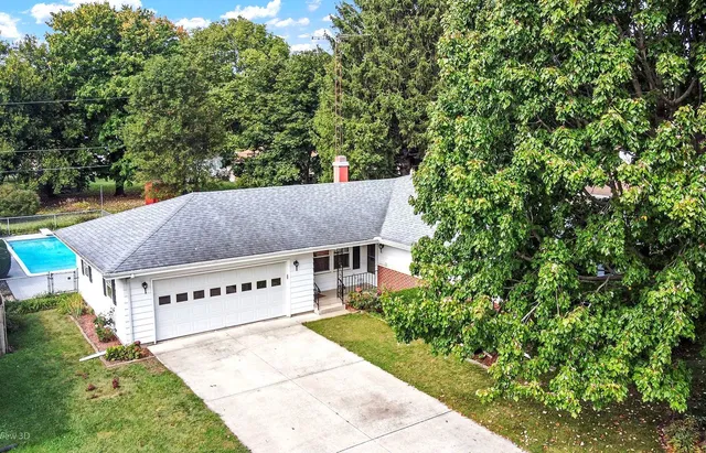 a view of house with yard and trees in the background