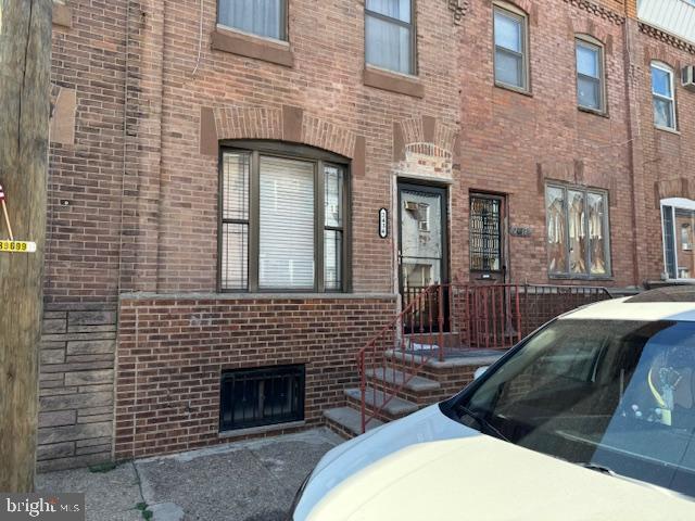 a couple of cars parked in front of brick building