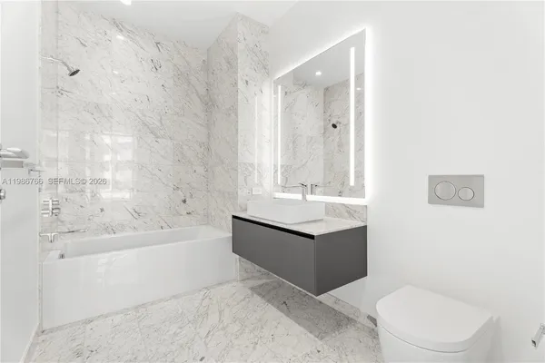 a bathroom with a double vanity sink mirror and bathtub
