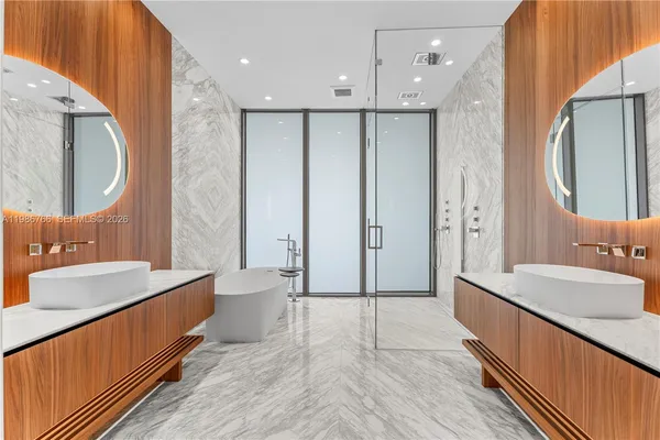 a bathroom with a double vanity sink mirror and shower