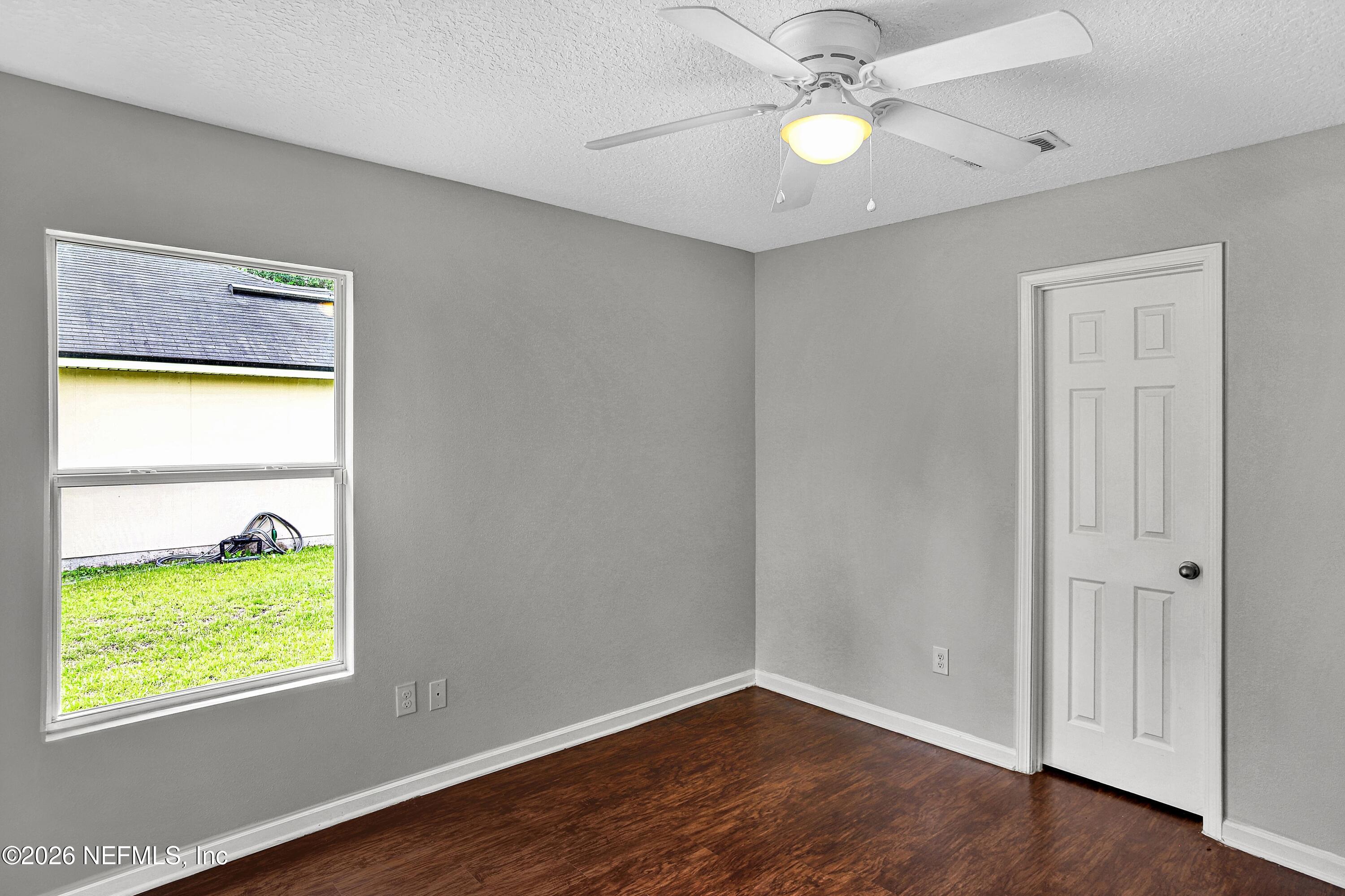 12271 Harts Road Jacksonville, FL 32218 - Photo 11 of 17 a view of an empty room with a window and wooden floor