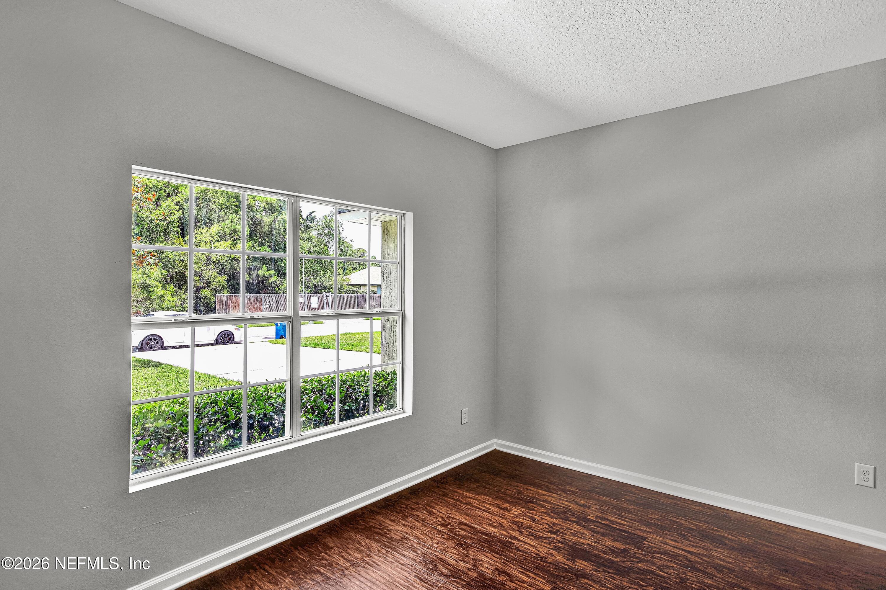 12271 Harts Road Jacksonville, FL 32218 - Photo 12 of 17 a view of an empty room with wooden floor and a window