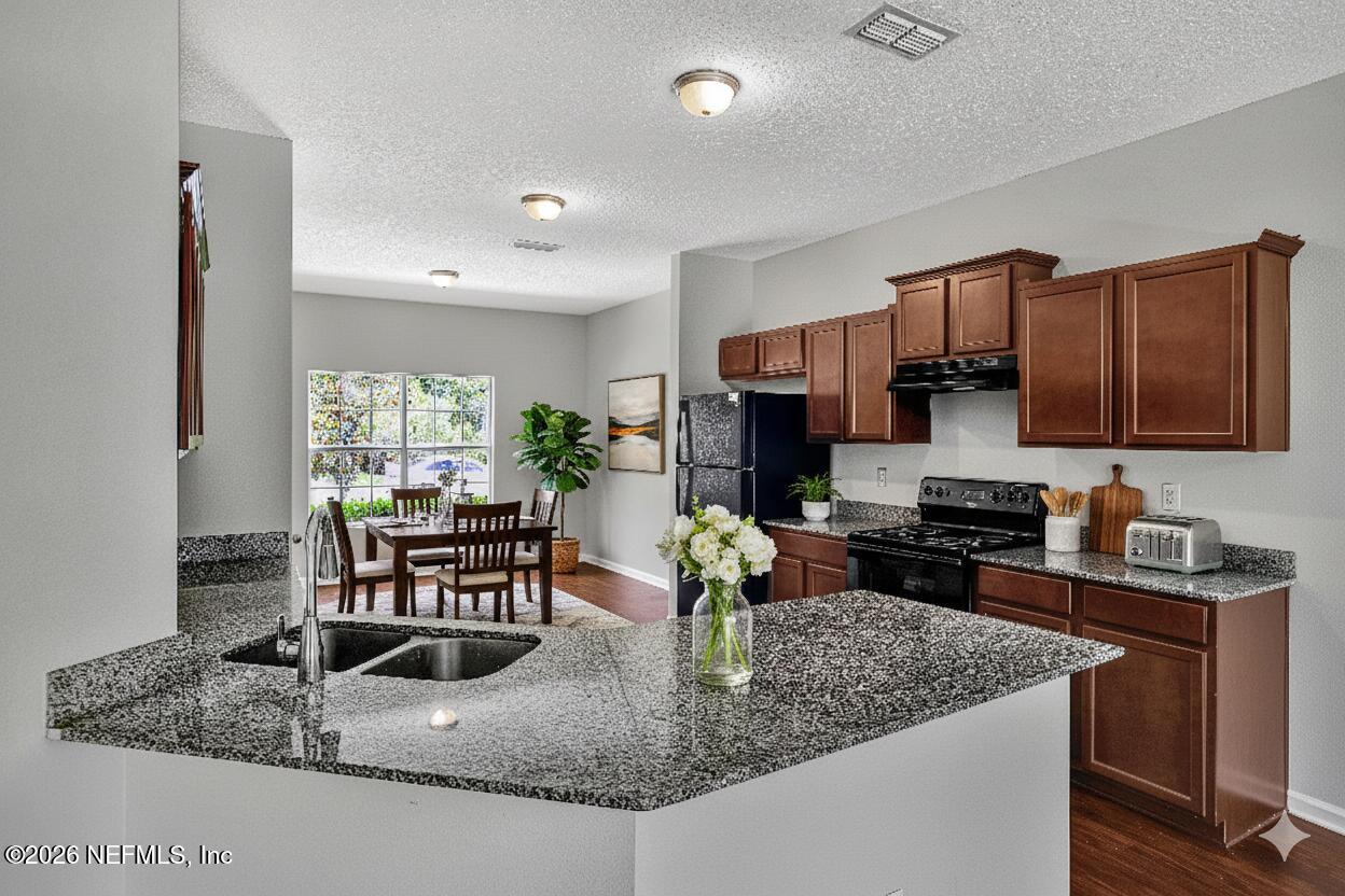 12271 Harts Road Jacksonville, FL 32218 - Photo 2 of 17 a kitchen with kitchen island granite countertop a sink and counter space