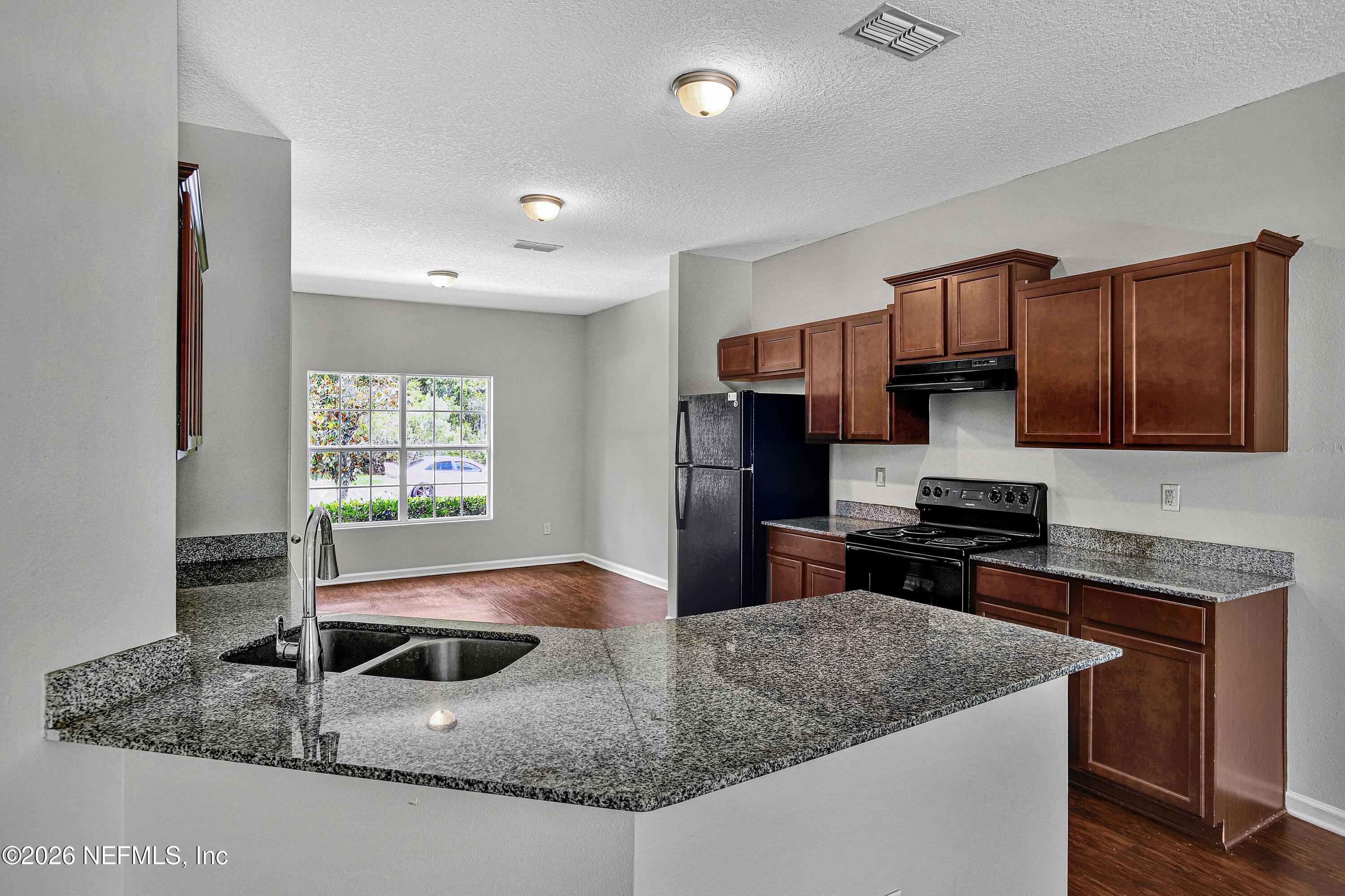 12271 Harts Road Jacksonville, FL 32218 - Photo 3 of 17 a kitchen with stainless steel appliances granite countertop a sink a stove and a refrigerator