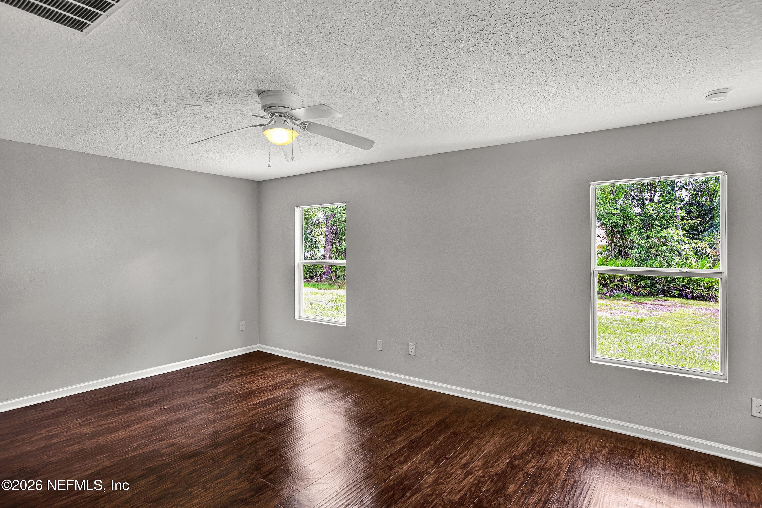 12271 Harts Road Jacksonville, FL 32218 - Photo 7 of 17 a view of an empty room with wooden floor and a window