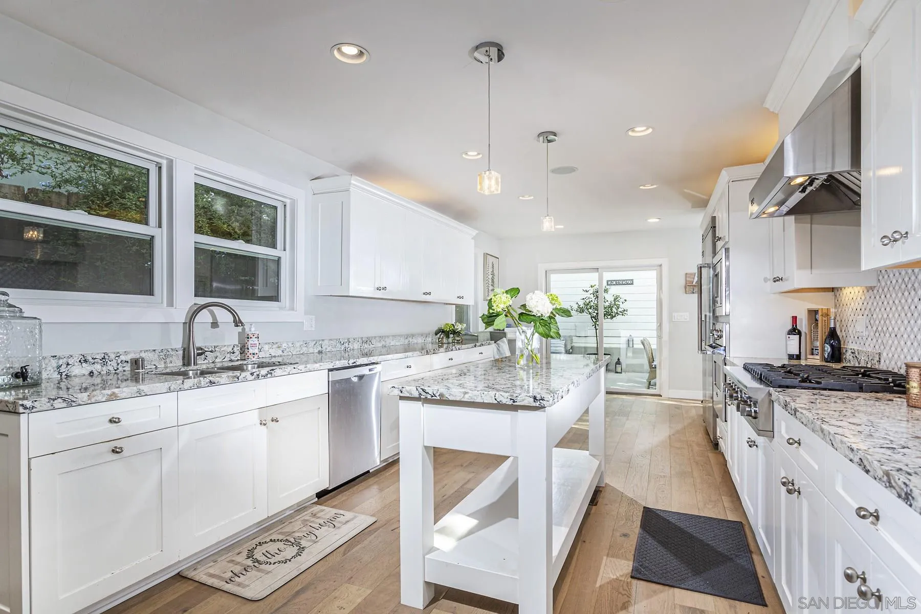 340 A Avenue Coronado, CA 92118 - Photo 11 of 41 a kitchen with granite countertop a sink stove cabinets and wooden floor