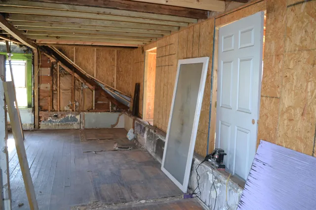 a view of a small space with wooden floor and a window