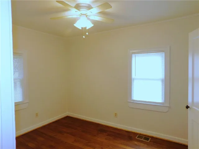 an empty room with a window and wooden floor