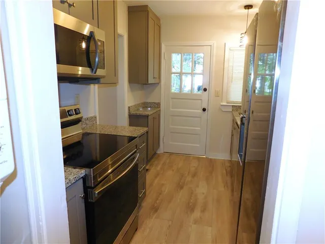 a kitchen with granite countertop a sink and a stove top oven