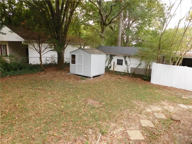 a view of a house with a yard and large tree