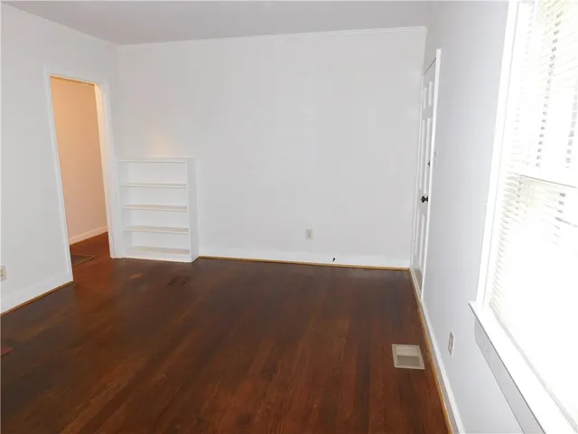 an empty room with wooden floor and closet