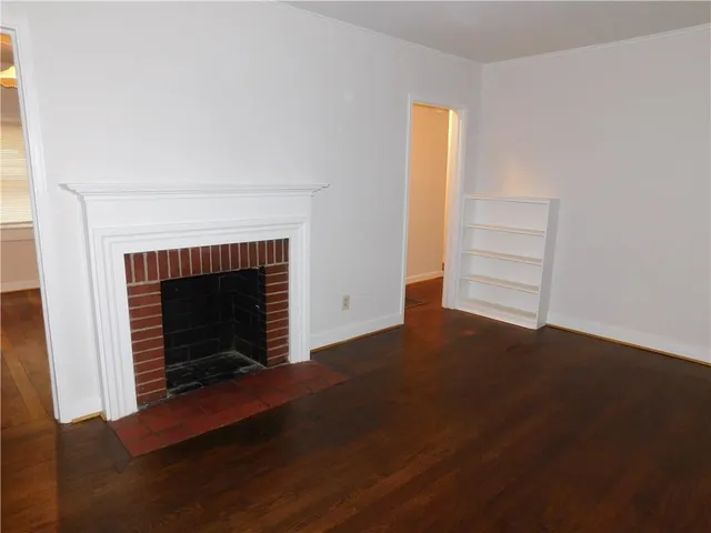 an empty room with windows and fireplace