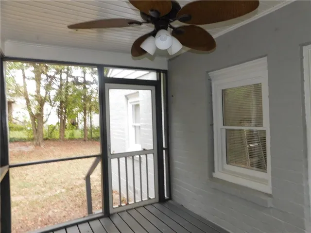 a view of a livingroom with a large window wooden floor and front door