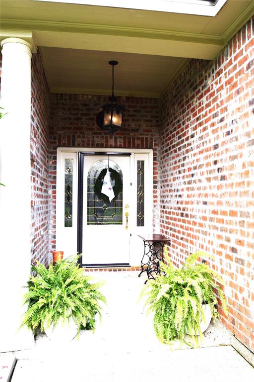 605 Jade Haughton, LA 71037 - Photo 2 of 34 Brick exterior featuring a covered entry, decorative overhead lighting fixture, and a white front door with sidelights