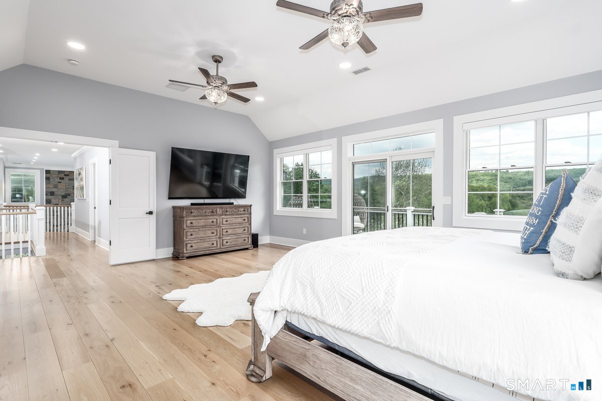 2 Pond View Lane Sherman, CT 06784 - Photo 21 of 40 a spacious bedroom with a large bed a flat tv screen and a dresser