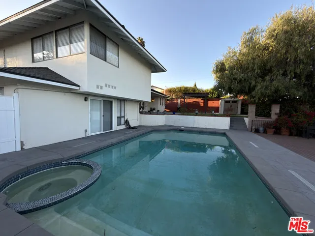 a view of a white house with a swimming pool