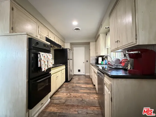 a kitchen with granite countertop a stove and cabinets