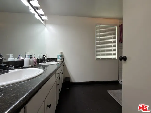 a bathroom with a double vanity sink and a mirror