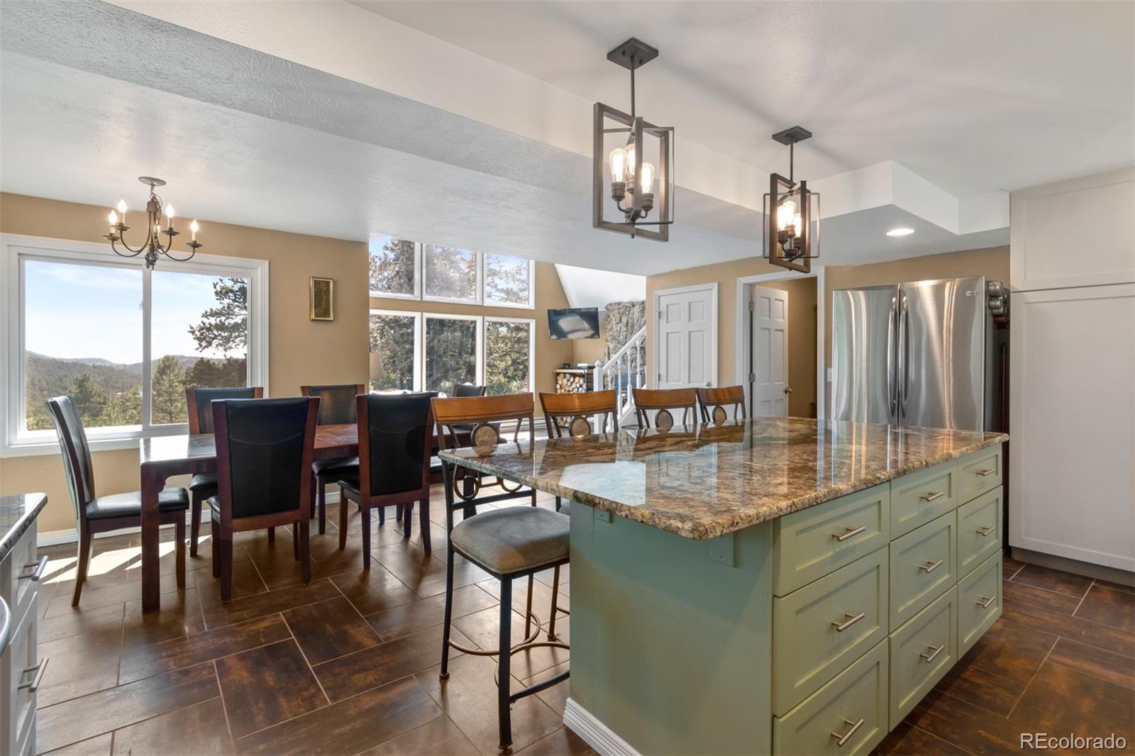 6637 High Drive Morrison, CO 80465 - Photo 12 of 28 a dining hall with stainless steel appliances kitchen island granite countertop a table chairs and a view of living room