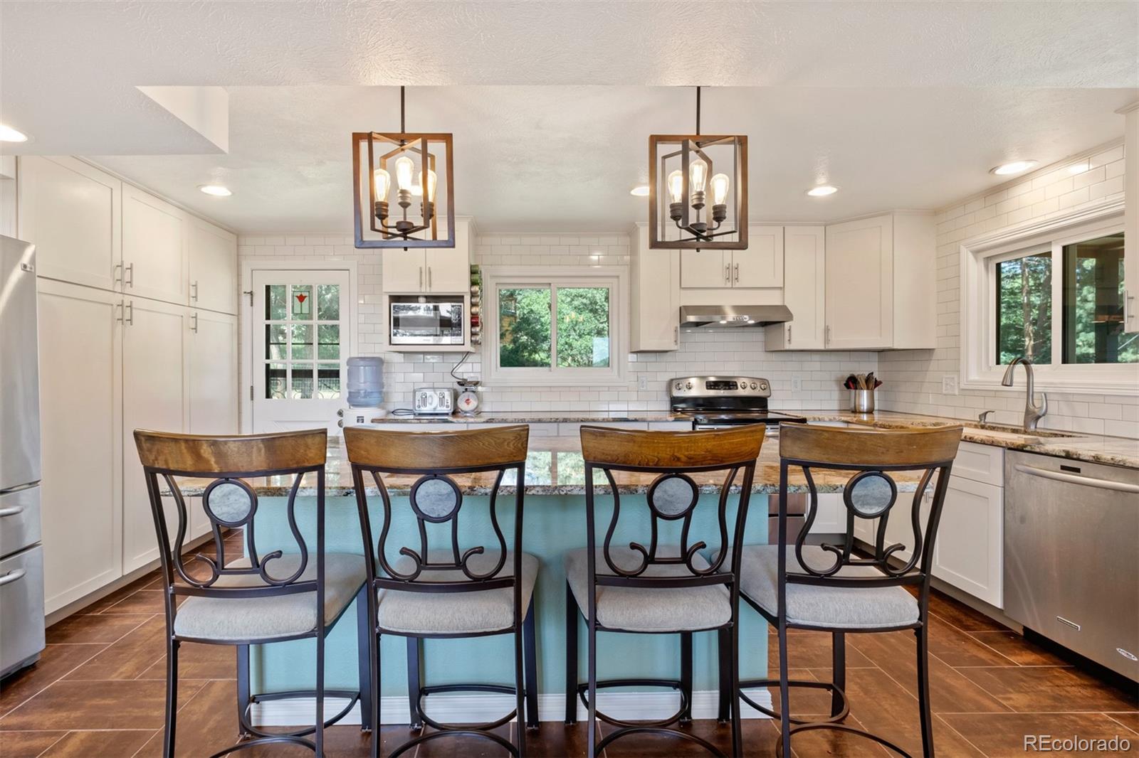 6637 High Drive Morrison, CO 80465 - Photo 9 of 28 a kitchen with stainless steel appliances a dining table and chairs