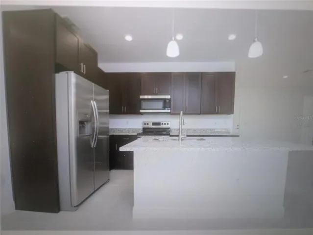 a kitchen with stainless steel appliances granite countertop a refrigerator and a stove