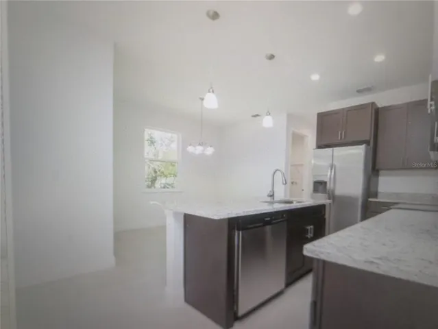 a kitchen with stainless steel appliances a sink and a refrigerator