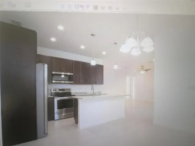 a kitchen with kitchen island a sink stainless steel appliances and cabinets