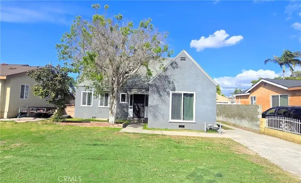 a view of a house with a big yard and large tree