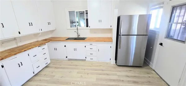 a kitchen with granite countertop a refrigerator and a sink