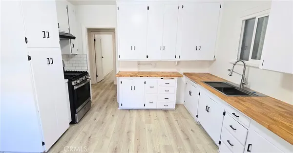 a kitchen with granite countertop a sink stove and refrigerator