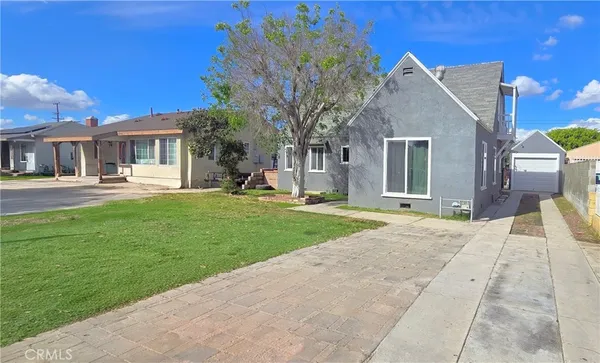 a front view of a house with a yard and trees