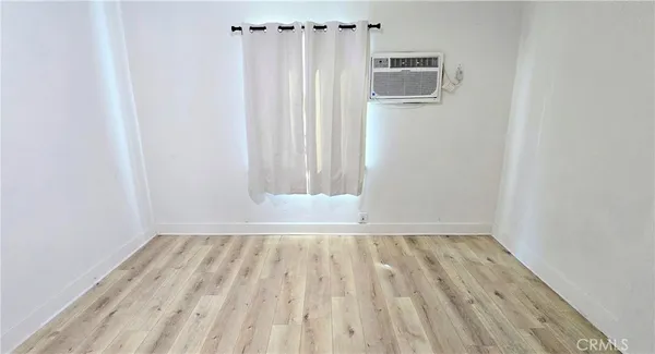 a view of a livingroom with wooden floor and a window