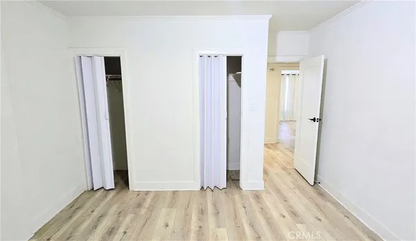 an empty room with wooden floor and a bathroom