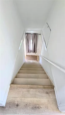 an empty room with wooden floor and a bathroom