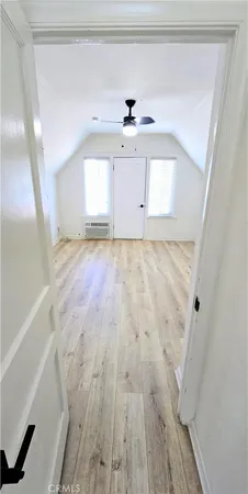 a view of empty room with wooden floor