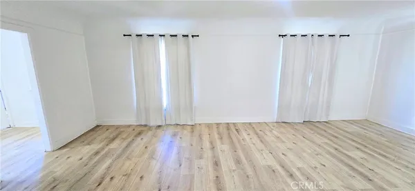 a view of a room with wooden floor closet and windows