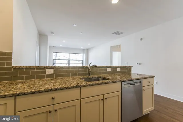 a kitchen with granite countertop cabinets sink and window