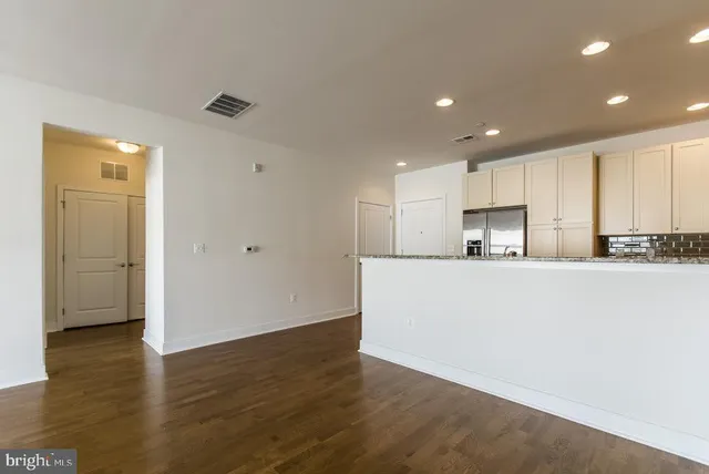 a view of kitchen with cabinets stainless steel appliances and wooden floor