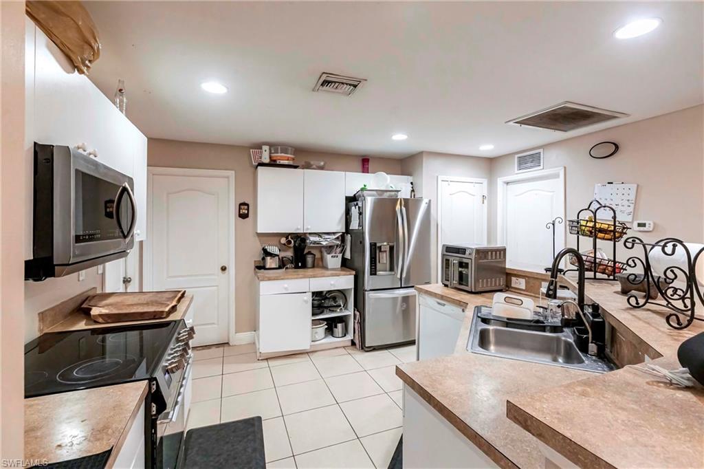 2900 8th Street Southwest Lehigh Acres, FL 33976 - Photo 11 of 32 a kitchen with refrigerator and microwave