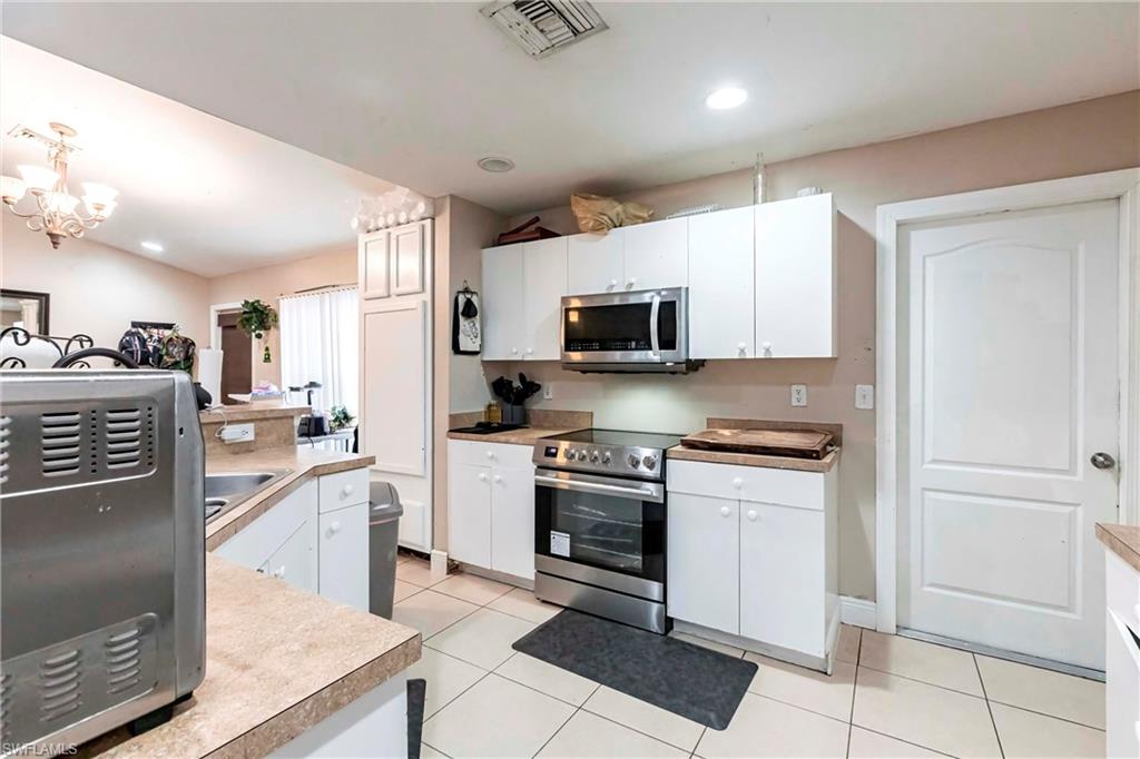 2900 8th Street Southwest Lehigh Acres, FL 33976 - Photo 13 of 32 a large kitchen with stainless steel appliances granite countertop a stove a sink dishwasher and a refrigerator