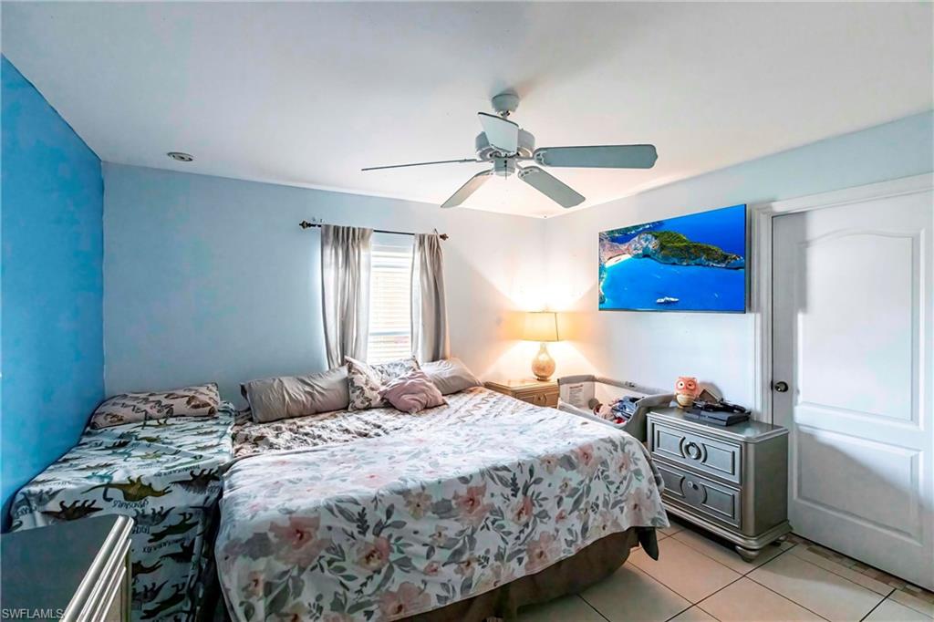 2900 8th Street Southwest Lehigh Acres, FL 33976 - Photo 14 of 32 a bedroom with a bed and a chandelier
